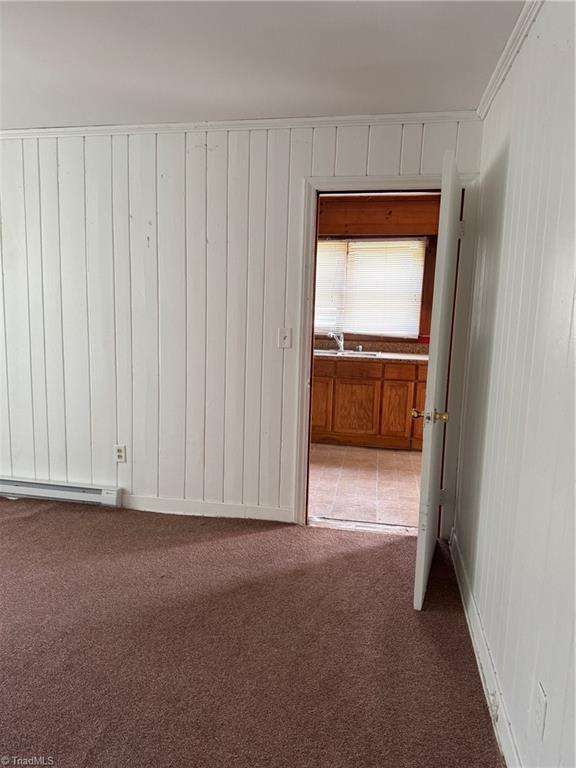 208-210 Long St, Thomasville, NC 27360 - empty room featuring carpet, baseboard heating, and crown molding
