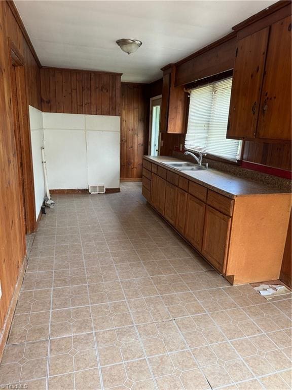 208-210 Long St, Thomasville, NC 27360 - kitchen featuring a sink, wooden walls, and brown cabinetry