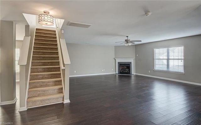 unfurnished living room featuring dark hardwood / wood-style floors and ceiling fan