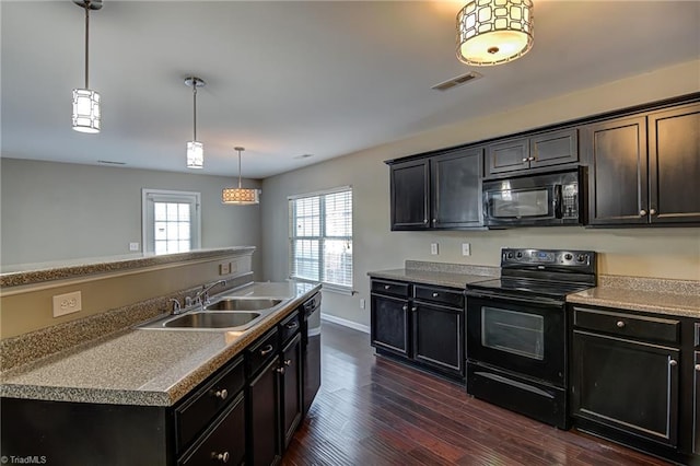 kitchen featuring black appliances, decorative light fixtures, sink, and dark wood-type flooring