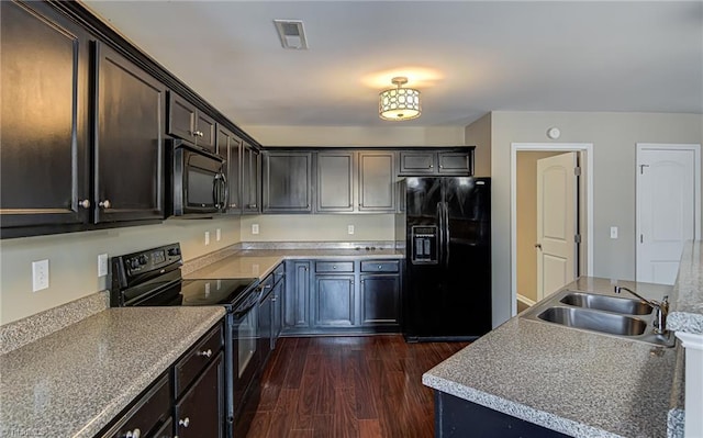 kitchen featuring dark hardwood / wood-style flooring, sink, and black appliances