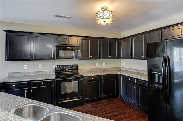 kitchen featuring sink, dark wood-type flooring, and black appliances