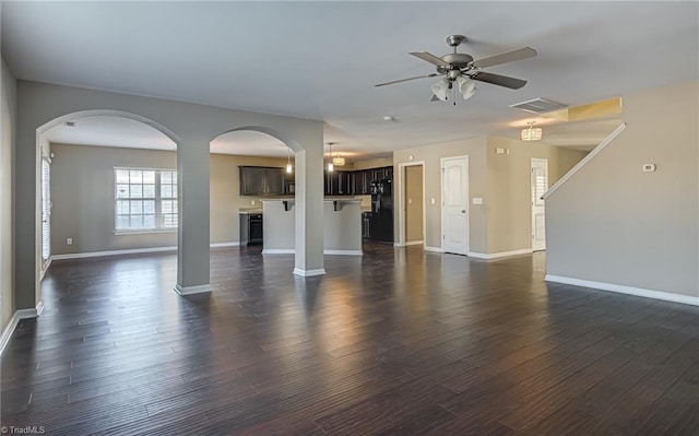 unfurnished living room with ceiling fan and dark wood-type flooring