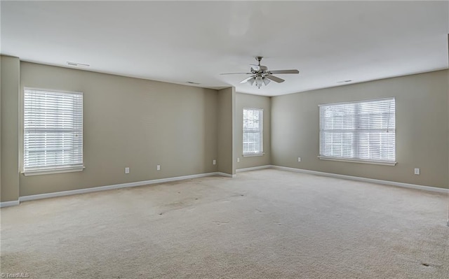 unfurnished room with light carpet, plenty of natural light, and ceiling fan