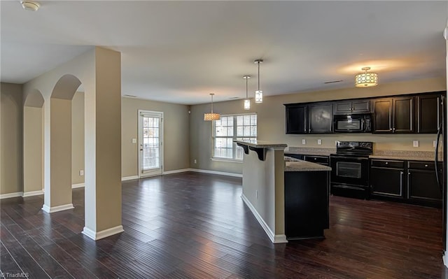 kitchen with a center island, hanging light fixtures, dark wood-type flooring, a breakfast bar area, and black appliances