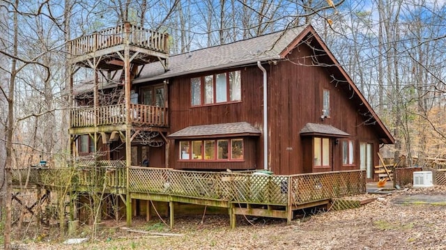 back of property with a shingled roof and a wooden deck