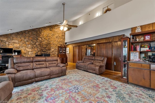 living room featuring a ceiling fan, lofted ceiling, and wood finished floors