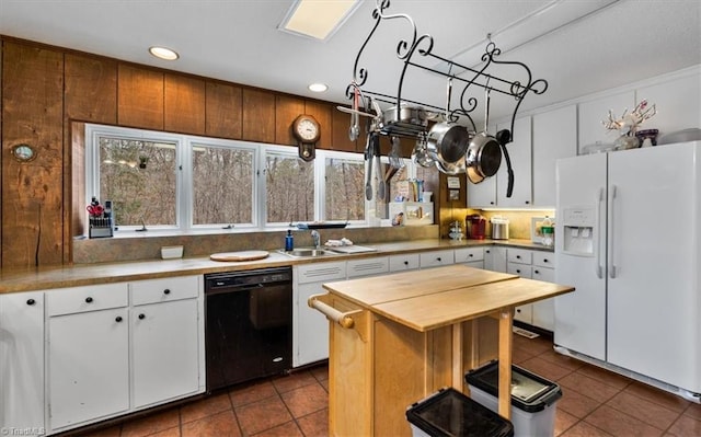 kitchen featuring black dishwasher, white refrigerator with ice dispenser, butcher block counters, dark tile patterned floors, and a sink