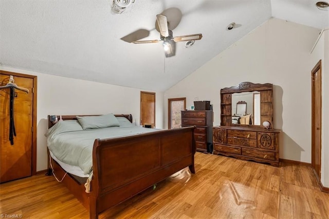 bedroom featuring light wood-type flooring, ceiling fan, baseboards, and lofted ceiling