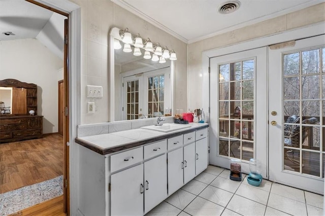 bathroom featuring french doors, visible vents, ornamental molding, vanity, and wood finished floors