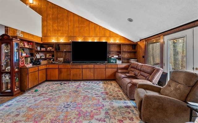 carpeted living area with wood walls, built in features, and vaulted ceiling