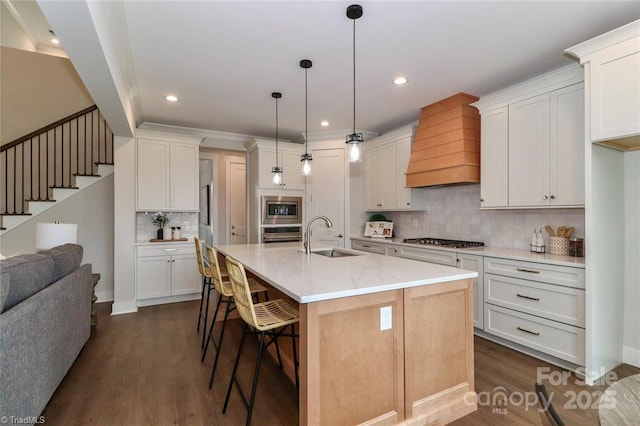 kitchen with a kitchen bar, dark wood-style flooring, stainless steel appliances, a sink, and custom exhaust hood