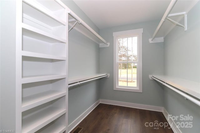 spacious closet featuring dark wood-style flooring and visible vents