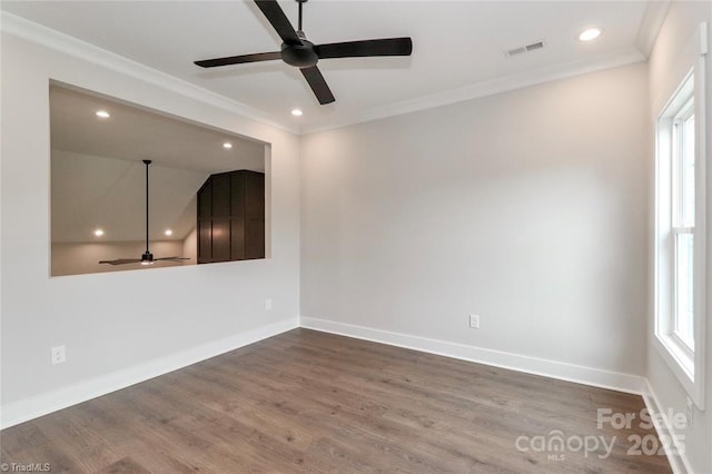 empty room featuring a healthy amount of sunlight, dark wood-style flooring, crown molding, and a ceiling fan