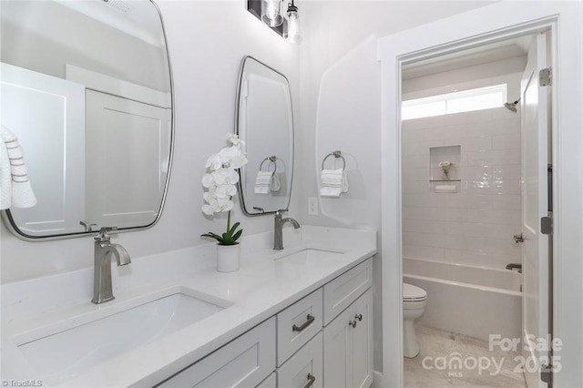 full bathroom with double vanity, toilet, bathtub / shower combination, and a sink