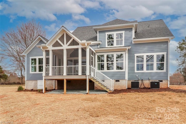 back of property featuring cooling unit, a sunroom, and roof with shingles