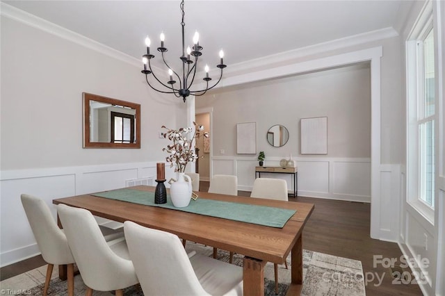 dining room with a wainscoted wall, dark wood-style floors, crown molding, and a chandelier