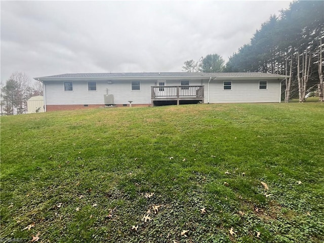 back of house featuring a wooden deck and a lawn