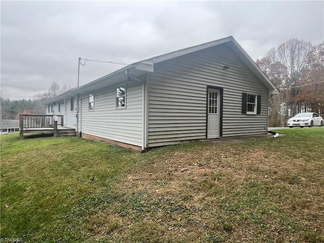 view of side of property featuring a lawn and a deck