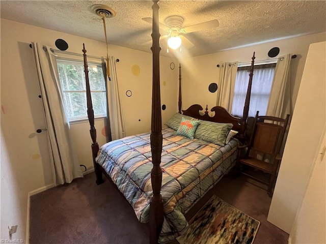 bedroom with ceiling fan, a textured ceiling, and dark carpet