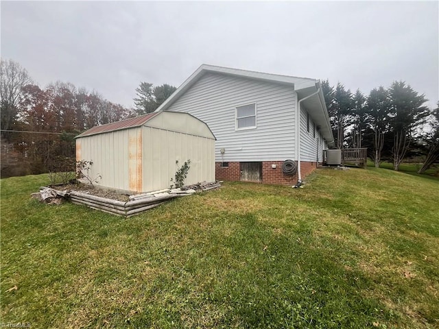 rear view of house with a lawn and a shed