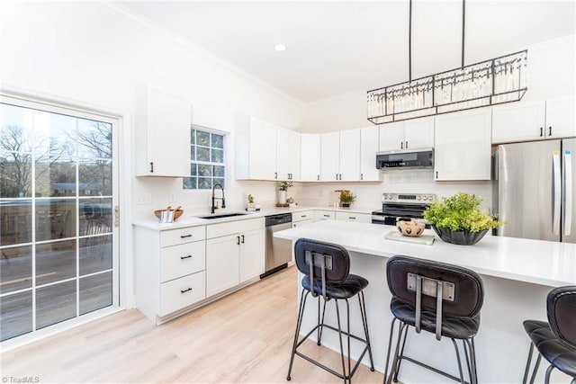 4114 Rose Lake Dr, Greensboro, NC 27407 - kitchen with white cabinets, appliances with stainless steel finishes, a kitchen bar, and sink