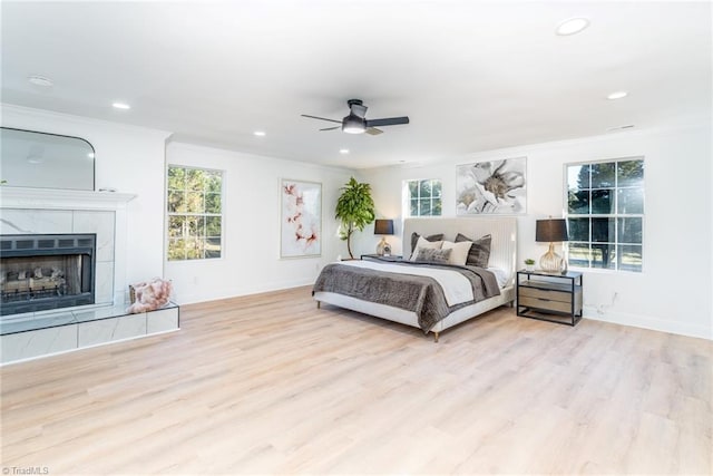4114 Rose Lake Dr, Greensboro, NC 27407 - bedroom featuring ceiling fan, light hardwood / wood-style floors, multiple windows, and a tiled fireplace