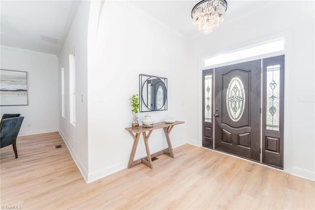 4114 Rose Lake Dr, Greensboro, NC 27407 - entryway featuring ornamental molding, light hardwood / wood-style flooring, a wealth of natural light, and a notable chandelier
