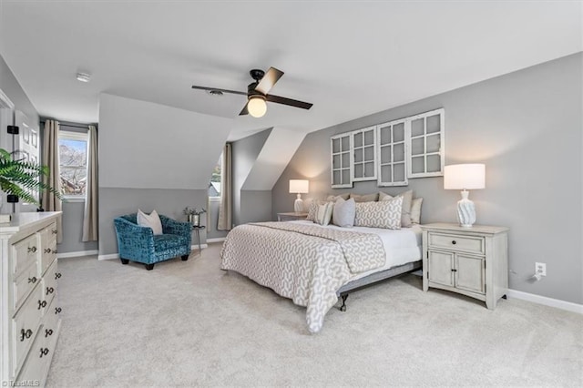 bedroom with vaulted ceiling, multiple windows, baseboards, and light carpet