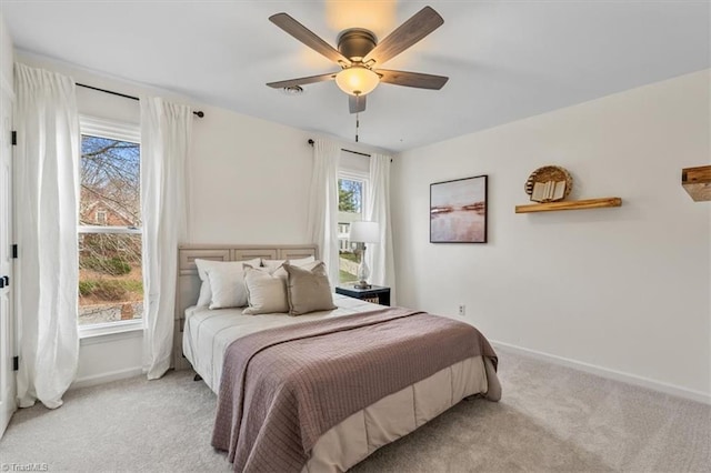 bedroom with light carpet, ceiling fan, and baseboards