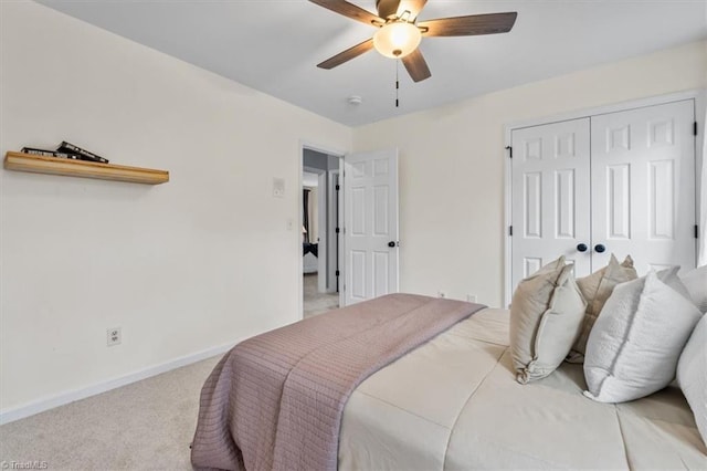 bedroom featuring light carpet, ceiling fan, a closet, and baseboards