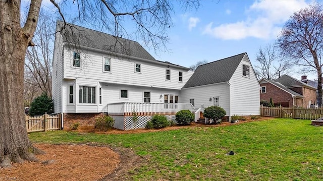 rear view of house with a wooden deck, a lawn, and a fenced backyard