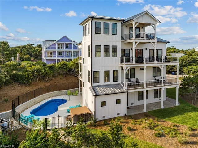 101 Melanie St, Emerald Isle, NC 28594 - back of property featuring board and batten siding, metal roof, a fenced backyard, and a balcony