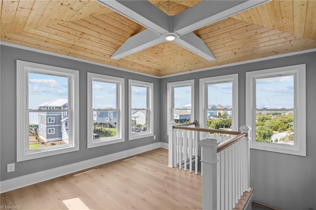 unfurnished sunroom featuring wood ceiling, beamed ceiling, and plenty of natural light