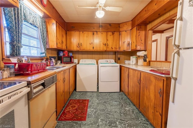 laundry area featuring ceiling fan, washing machine and dryer, and sink