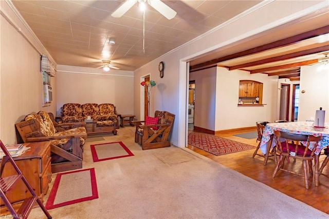 living room featuring ceiling fan, ornamental molding, wood-type flooring, and beam ceiling