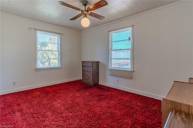 empty room with crown molding, ceiling fan, carpet flooring, and a wealth of natural light