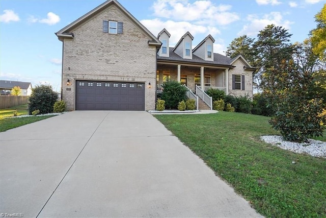 view of front of home with a front yard, a garage, and covered porch