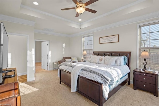 carpeted bedroom with a raised ceiling, ceiling fan, and crown molding