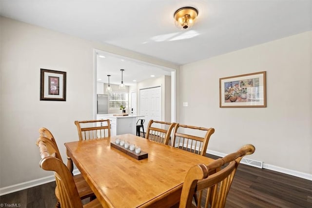 dining space with dark hardwood / wood-style flooring