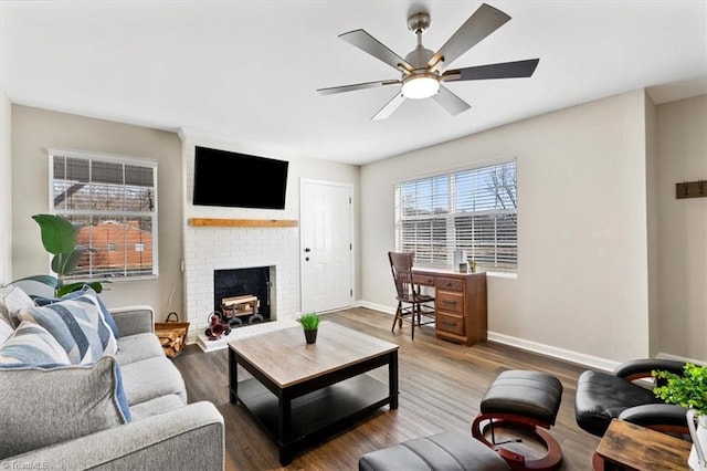 living room with hardwood / wood-style floors, a fireplace, and ceiling fan