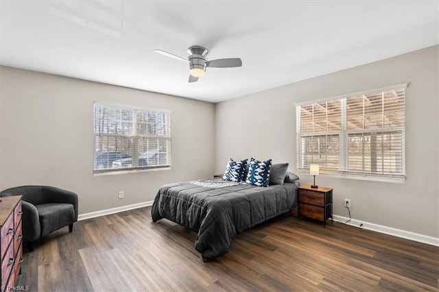 bedroom with ceiling fan, dark hardwood / wood-style floors, and multiple windows