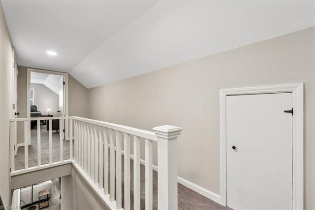 corridor with lofted ceiling and carpet floors