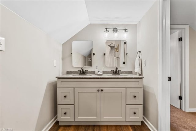 bathroom featuring vanity and lofted ceiling