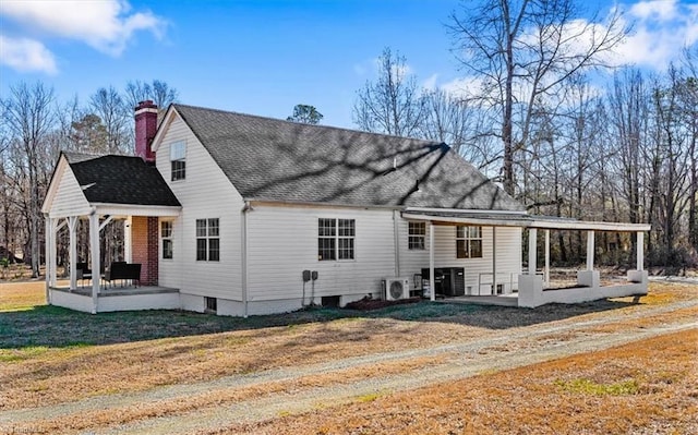 rear view of house with cooling unit, a yard, and a patio