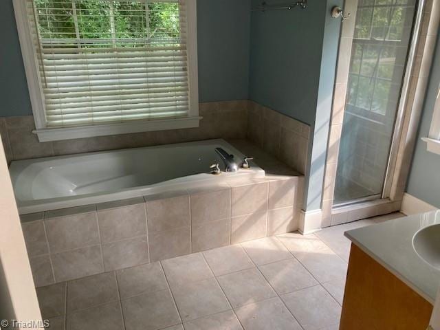 bathroom featuring tile patterned flooring, shower with separate bathtub, and vanity