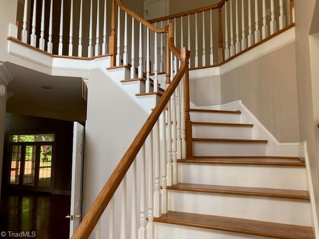 stairway featuring french doors and a towering ceiling