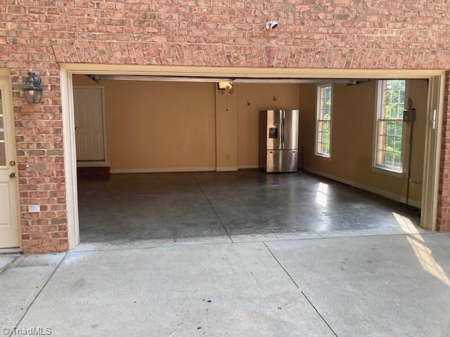 garage with stainless steel fridge with ice dispenser