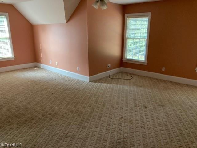 additional living space with ceiling fan, carpet floors, and vaulted ceiling