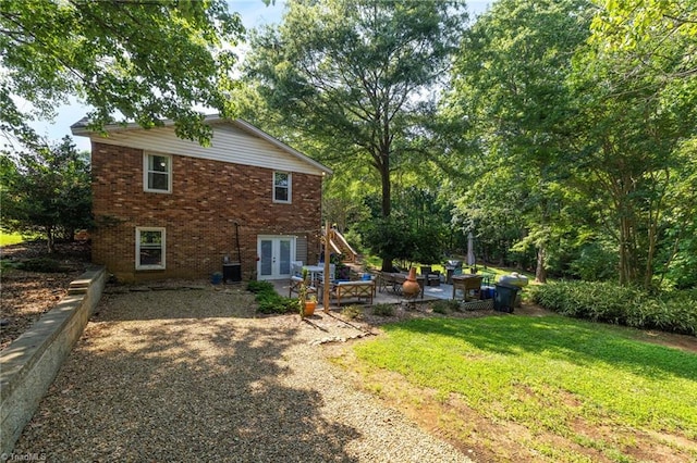 8194 Brotherstwo Rd, Colfax, NC 27235 - rear view of property with french doors, a patio, brick siding, and a lawn